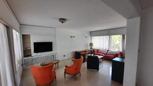 门多萨新别墅度假屋的客厅配有橙色椅子和沙发