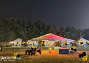 阿格拉Agra Camps and Resort的田野上带桌椅的帐篷