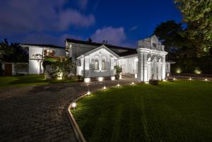 科伦坡玛尼帕西度假酒店的白色的房子,在草坪上点灯
