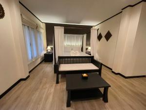 清迈Na Mantra Resort的客厅配有床和桌子