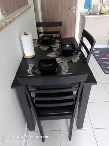 汝来MEDINA's 5STAR CondoSTAY in Nilai的一张桌子,两把椅子,一张黑桌子,椅子,四色 ⁇ 子