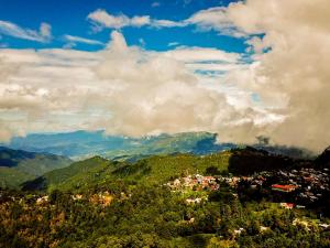 El PacíficoAlto de la Sierra by Rotamundos的享有山丘上的小镇和山脉的景色