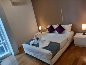 吉隆坡Grand Suite at Platinum KLCC的一间卧室配有一张床,床上有浴袍