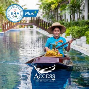 卡伦海滩Access Resort & Villas - SHA Plus的船上的男孩,拿着一捆香蕉