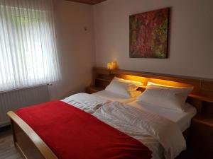 施马伦贝格Gasthof-Pension Hunaustuben的一间卧室配有两张带红毯的床