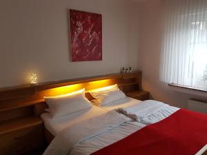 施马伦贝格Gasthof-Pension Hunaustuben的一间卧室配有两张床和红色毯子