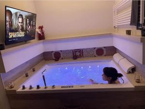 贝尔纳尔达MAD SUITES & APARTMENTS的电视按摩浴缸中的女性