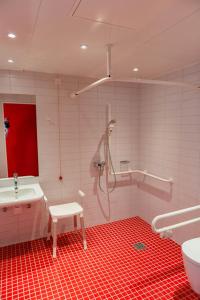 库克斯港库克斯港旅舍的带淋浴的浴室和红色地板。