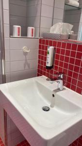 库克斯港库克斯港旅舍的浴室铺有红色瓷砖,配有白色水槽。
