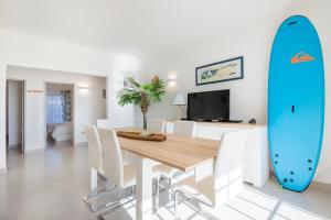 卢斯Beautiful Seaview 2 Bedroom Apartment的用餐室配有桌子和冲浪板。