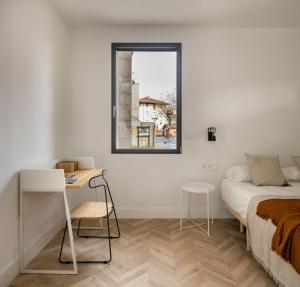 巴基奥SOLOA LANDETXEA的一间卧室配有一张床、一张书桌和一个窗户。