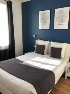 图尔Hôtel Saint Eloi的一间卧室配有一张带蓝色墙壁的大床