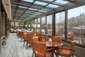 伊斯坦布尔伊斯坦布尔莱文特凯悦酒店的餐厅设有桌椅和大窗户。