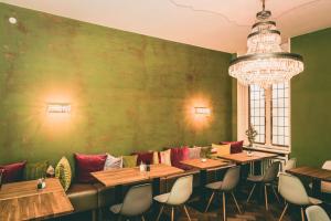 威斯巴登Hotel Villa Klemm - Wiesbaden City的餐厅的一排桌子,有绿色的墙壁