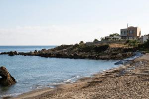 PetresAn intimate Villa Resort- Right on the beach, by ThinkVilla的海滩上设有椅子和遮阳伞,还有大海