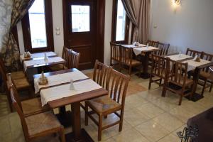 Ágios AthanásiosΞενώνας Παρατηρητήριο Υπερώον的餐厅设有木桌、椅子和窗户。