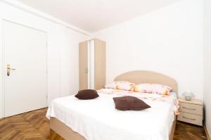 杜布罗夫尼克卡塔利纳客房酒店的一间白色卧室,配有一张床和一个梳妆台
