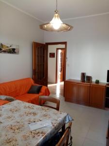 科莱尼奥BRUNO TURIN APARTMENT Near the METRO的客厅配有橙色沙发和桌子