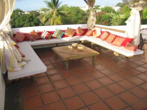 弗利康弗拉克彩虹别墅旅馆的庭院内白色的沙发,配有色彩缤纷的枕头