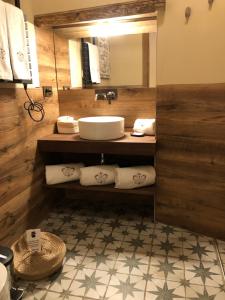 纳瓦尔卡内罗Hotel Boutique Casa del Comendador的浴室配有盥洗盆、镜子和毛巾