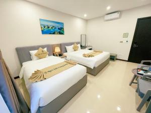 下龙湾Ngọc Ánh Dương Hotel的配有两张床的酒店客房