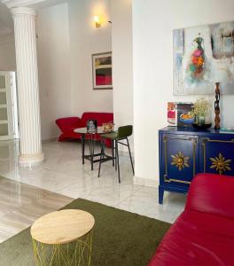 达喀尔Francesca Guest House的客厅配有红色的沙发和桌子