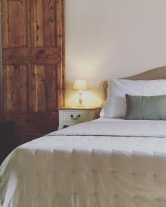 皮恩扎Vento d’Orcia的卧室配有白色的床和木门