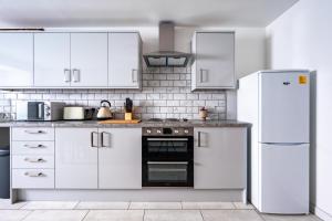 格拉斯哥Dalhousie Lower的厨房配有白色橱柜和冰箱。