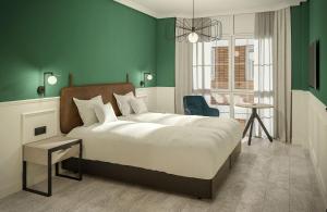 帕伦西亚唐罗德里戈酒店的一间卧室设有一张大床和绿色的墙壁