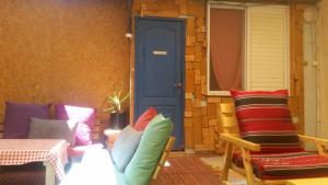 米茨佩·拉蒙Spice Quarter Inn的一个带蓝色门、椅子和桌子的门廊