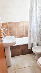 圣罗莎Poas - Alquiler temporario的一间带水槽、浴缸和卫生间的浴室