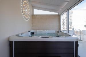 莱切Ada Suites & Spa的一间带按摩浴缸和窗户的浴室