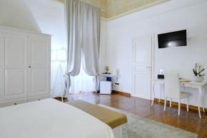 莱切Ada Suites & Spa的白色卧室配有床和书桌
