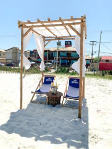 卡波布里奥PIER BEACH CLUB的海滩上的两把椅子和一张桌子