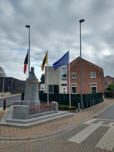 迪尔森-斯托科姆Vakantiewoning 'De Vlaamse Aap'的建筑物前方有旗帜的纪念碑