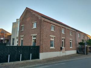 迪尔森-斯托科姆Vakantiewoning 'De Vlaamse Aap'的街道边的红砖建筑