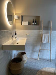 登博斯KASerne Boutique Hotel的浴室设有水槽、镜子和篮子