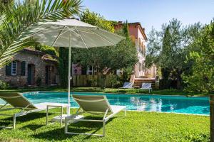 萨雷尔讷Gites de la Villa Pergola的游泳池旁的一对椅子和一把遮阳伞