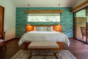 Toro AmarilloEl Silencio Lodge & Spa Costa Rica的一间卧室设有一张大床和一个窗户。