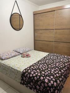 大普拉亚Apartamento aconchegante 1 quadra da praia的一间卧室配有床和鲜花梳妆台。