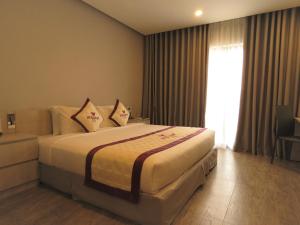 河仙VISUHA HOTEL的卧室配有带枕头的床铺和窗户。