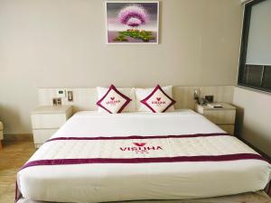河仙VISUHA HOTEL的卧室配有一张带两个枕头的大白色床