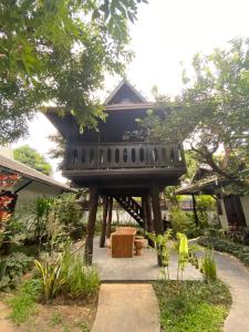 清迈Na Mantra Resort的花园中一座带黑色屋顶的房子