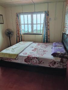 昆达桑Kinabalu Valley Guesthouse的窗户客房内的一张床位