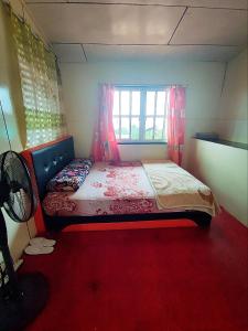 昆达桑Kinabalu Valley Guesthouse的一间小卧室,配有一张带窗户的床