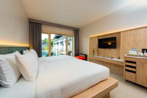 奥南海滩Holiday Ao Nang Beach Resort, Krabi - SHA Extra Plus的卧室配有一张白色大床和电视。