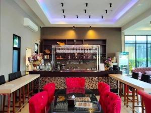 莱卡邦Pongsakorn Boutique Resort -SHA Extra Plus的一间设有红色椅子的餐厅和一间酒吧