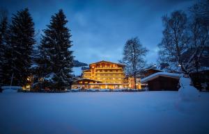 萨尔巴赫格莱玛塔勒霍夫酒店的一座大建筑物,在晚上下雪