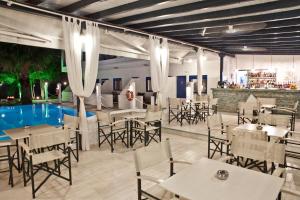 新马尔马拉斯亚里亚尼蓝色旅馆的一间带桌椅的餐厅和一个游泳池