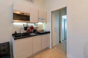米兰Scarlatti Luxury apt. - B. Aires / Central Station的厨房配有白色橱柜和水槽